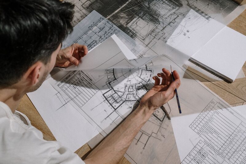 Architect aan de ontwerptafel met bouwtekeningen voor een Amsterdams verbouwingsproject