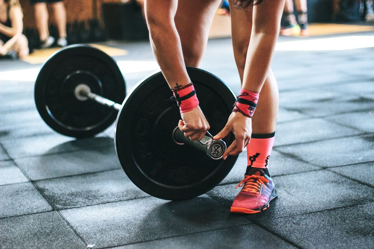 Drukbezochte sportschool in Amsterdam met leden die trainen aan de toestellen